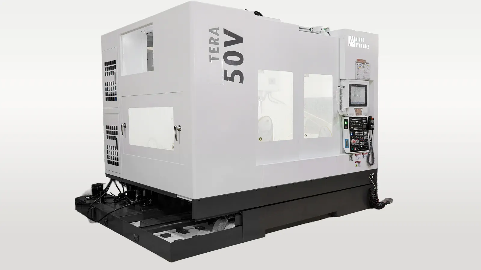 A MicroDynamics Tera 50V Vertical Machining Center CNC Machine with a Auger (Screw) Conveyor showing the compact size of this combination